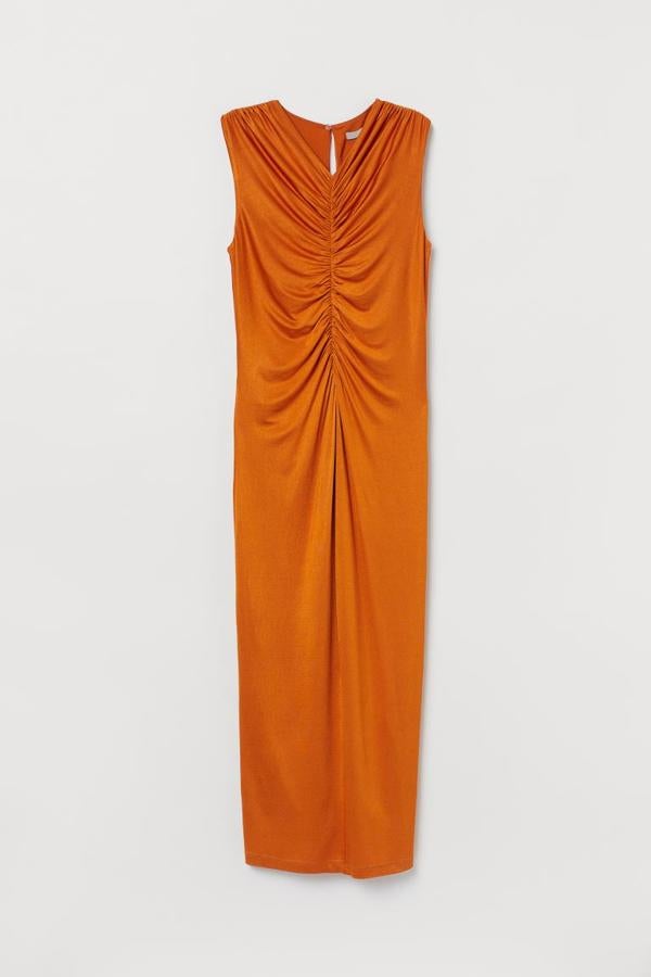 Diseño drapeado en color naranja para este vestido tobillero sin mangas confeccionado en punto elástico de acetato de celulosa. Con acabado brillante, está a 37,99 euros (49,99 euros) y todavía podemos encontrarlo en las tallas XS, S y M.