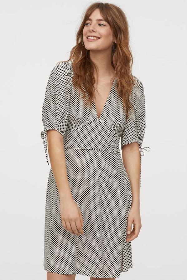 Este vestido vaporoso en mezcla de viscosa y lyocell sostenible viene con un bonito estampado de lunares negros sobre blanco. Con mangas cortas abullonadas y lazada decorativa en el puño, en la cintura tiene un ribete de cinta. Cuesta 14,99 euros (19,99 euros) y está disponible en las tallas 32 y 34.