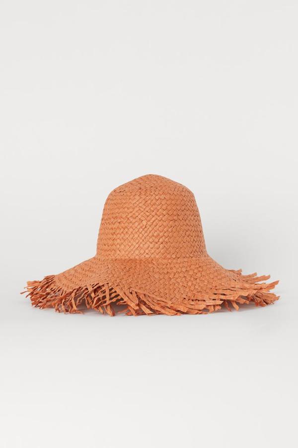 Sombrero de paja desflecada en color naranja, de H&M (10,99 euros).
