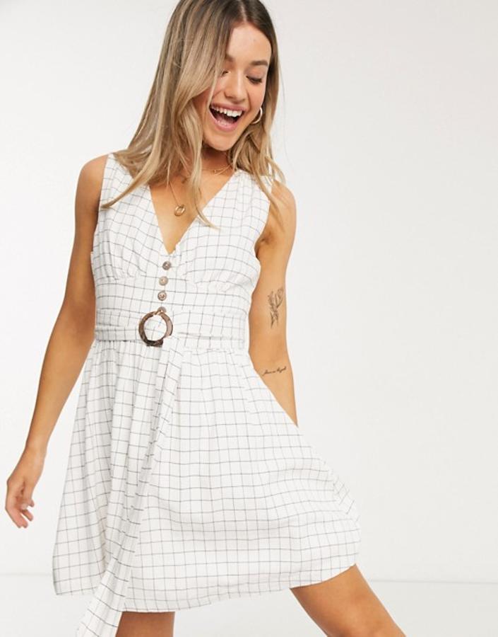 Con escote de pico, tirantes anchos y cinturón a tono con hebilla a contraste, este bonito vestido blanco con cuadro negro es de Gilli y podemos encontrarlo en Asos. Tenía un precio de 102,99 euros y ahora puedes comprarlo por 35,99 euros en las tallas M y L.
