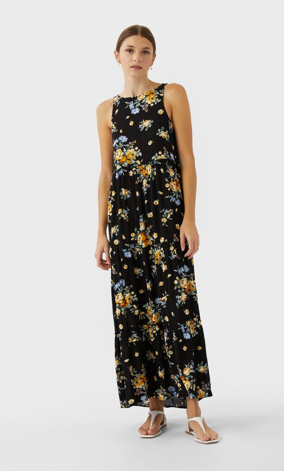 Más sobrio pero igual de favorecedor: vestido largo negro con estampado de flores. (25,99 euros).