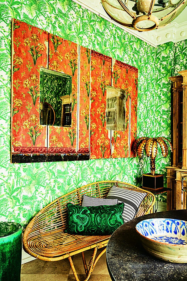 Cuarto entelado con hilo inglés de ramas verdes. Al fondo, biblioteca francesa de roble y espejos antiguos enmarcados en papel con estampado floral.