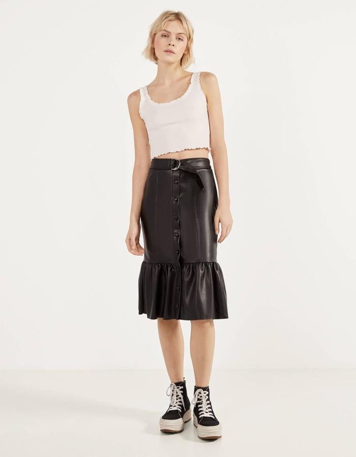 Falda de efecto piel, con forma lápiz y volante en el bajo, de las segundas rebajas de Bershka (9,99 euros).