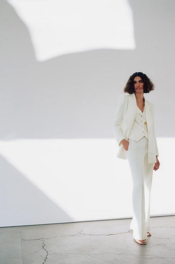 La blazer y el pantalón de este traje en color crudo están confeccionadas en tejido de mezcla de lino y algodón. La primera cuesta 59,95 euros y el segundo 39,95 euros.