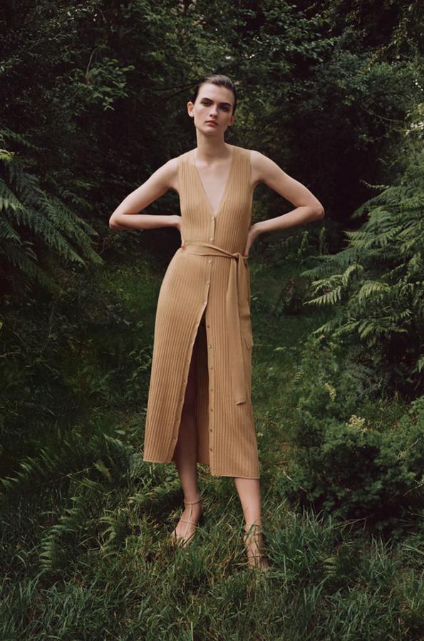 Escote de pico y manga sisa para este vestido largo de punto de Zara con cierre frontal con botones y cinturón a tono con lazada. Cuesta 29,95 euros y está disponible en las tallas S, M y L.