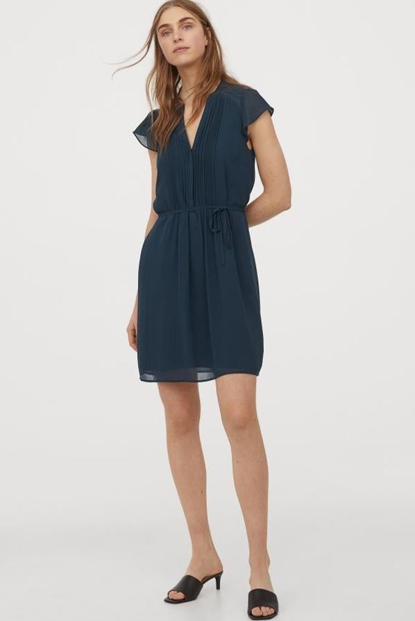 Una de nuestras propuestas favoritas es este bonito vestido vaporoso de H&M en color petróleo. De diseño mini, confeccionado en gasa, con escote de pico y manga corta, viene con cinturón de anudar a tono cosido. Cuesta 29,99 euros y está disponible únicamente en las tallas 32, 34 y 36.