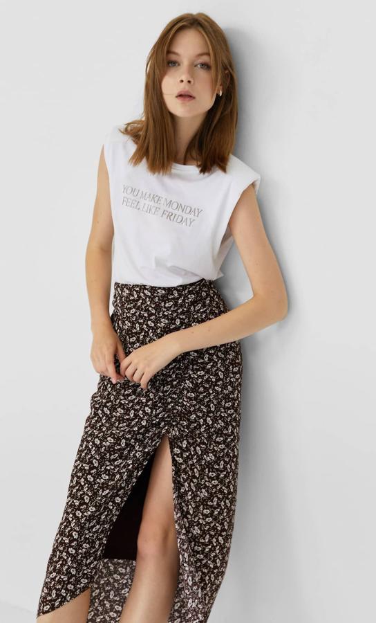 Fondo en color marrón con estampado floral blanco para esta falda de Stradivarius en diseño lápiz, con detalle de frunces y abertura en el frontal. Con un precio de 19,99 euros, está disponible entre las tallas XS y XL.