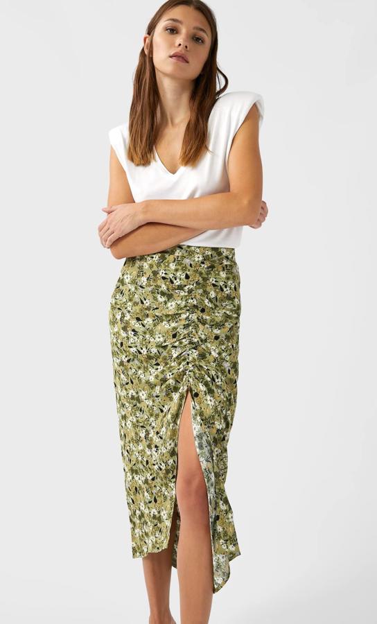 En color verde, con estampado floral en tonos blancos, esta falda lápiz de Stradivarius viene con detalle de frunces y abertura en el frontal. Cuesta 19,99 euros y está disponible entre las tallas XS y XL.