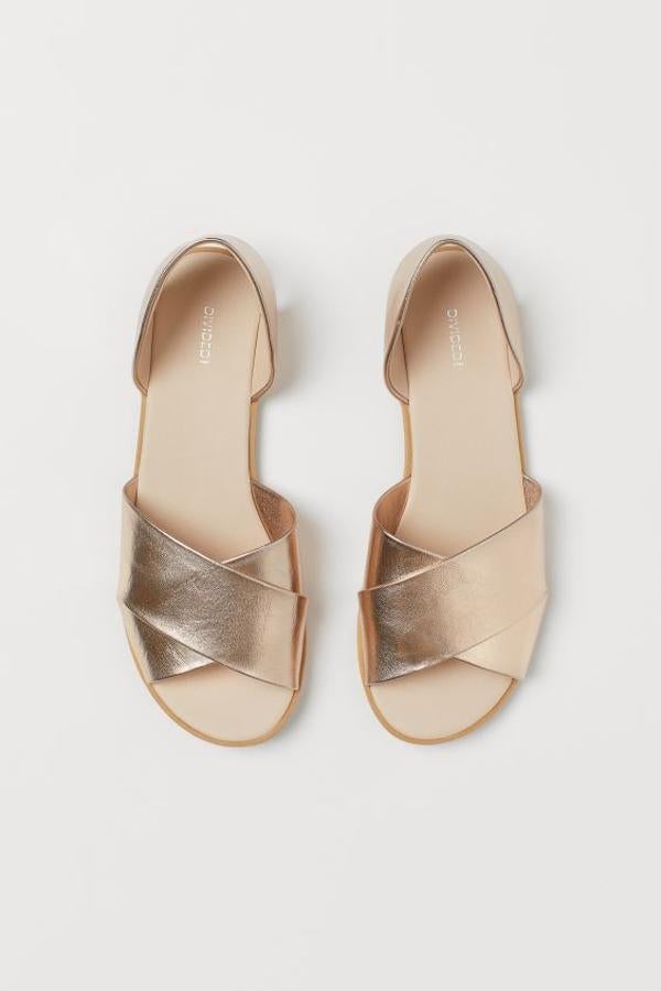 Con laterales abiertos, tiras cruzadas delante y puntera abierta, estas sandalias planas en dorado rosáceo son de H&M y cuestan 14,99 euros. Solo quedan en los números 37,38 y 39.