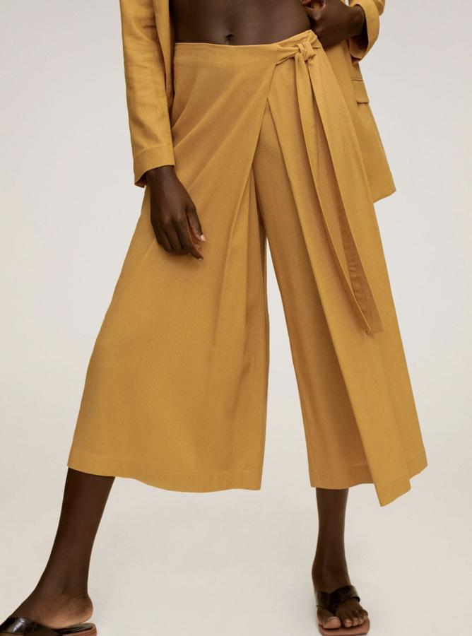 En color amarillo curry, este pantalón acampanado de tejido fluido y cinturón ajustable tiene un precio de 19,99 euros.