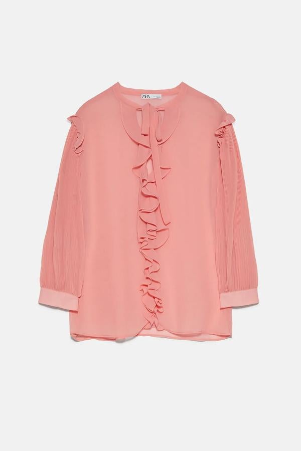 En color salmón, esta blusa semitransparente con cuello redondo con lazada y escote de pico cuenta con manga plisada por debajo del codo y tiene un precio de 9,99 euros.