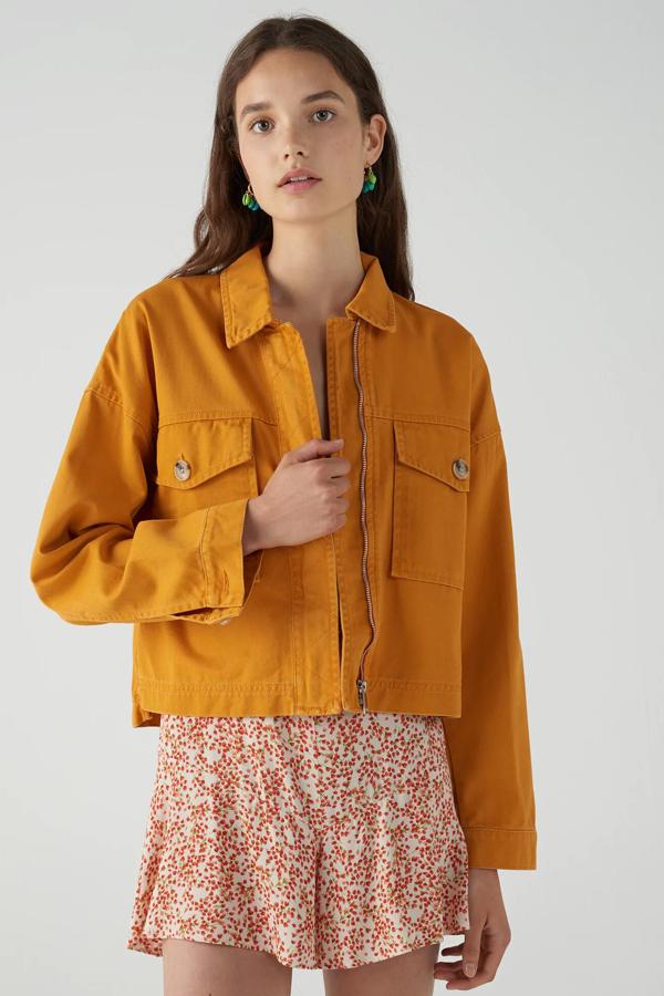 Esta cazadora vaquera de Pull & Bear en color naranja cuenta con cierre mediante cremallera y bolsillos en la parte delantera. Tiene un precio de 12,99 euros.