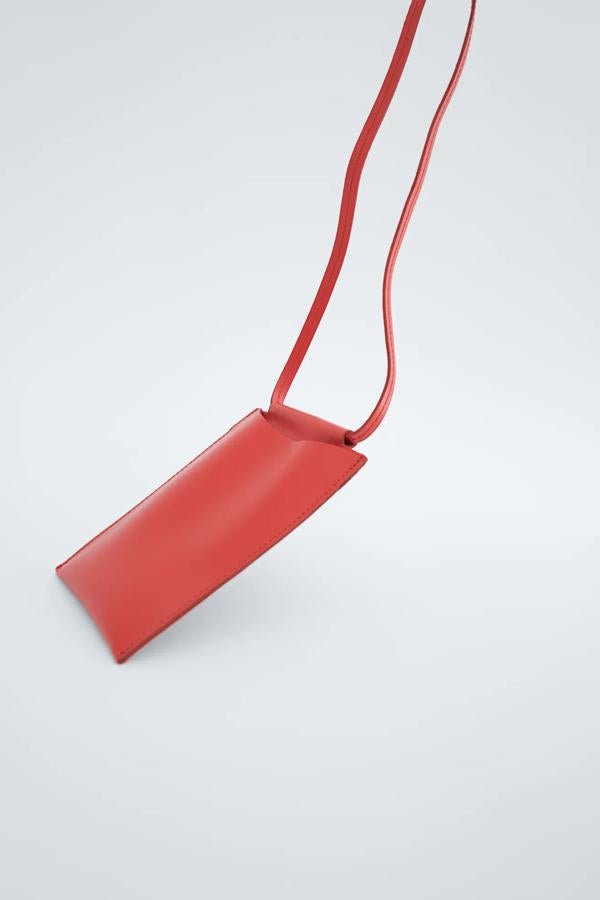 Disponible en rojo, negro o amarillo, esta funda para el teléfono móvil de piel dispone de un asa de hombro para llevar colgado. Es de Zara y tiene un precio de 19,99 euros.