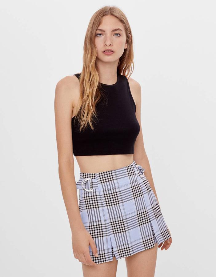 En Bershka hemos encontrado esta falda bermuda en color azul claro con estampado de cuadros y hebillas en la cintura. Tiene un precio de 17,99 euros y está disponible entre las tallas 32 y 42.
