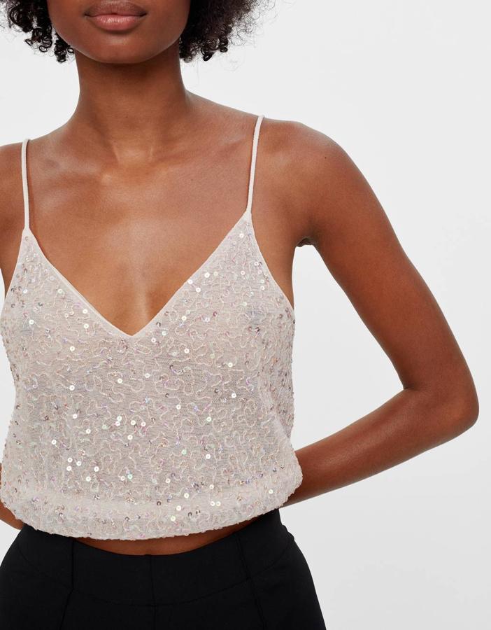 En color rosa y con adornos de lentejuelas, este top corto de Bershka tiene un precio de 17,99 euros y está disponible entre las tallas XS y L.