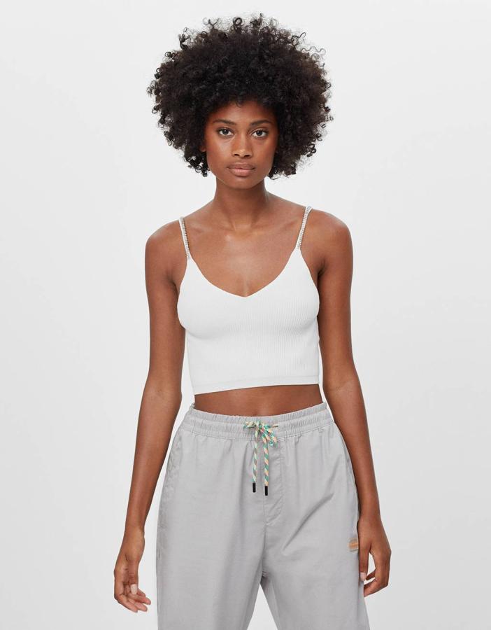 Con brillantes en los tirantes finos, este top corto de Bershka que podemos comprar en crudo, blanco y negro cuesta 15,99 euros y está disponible entre las tallas XS y L.