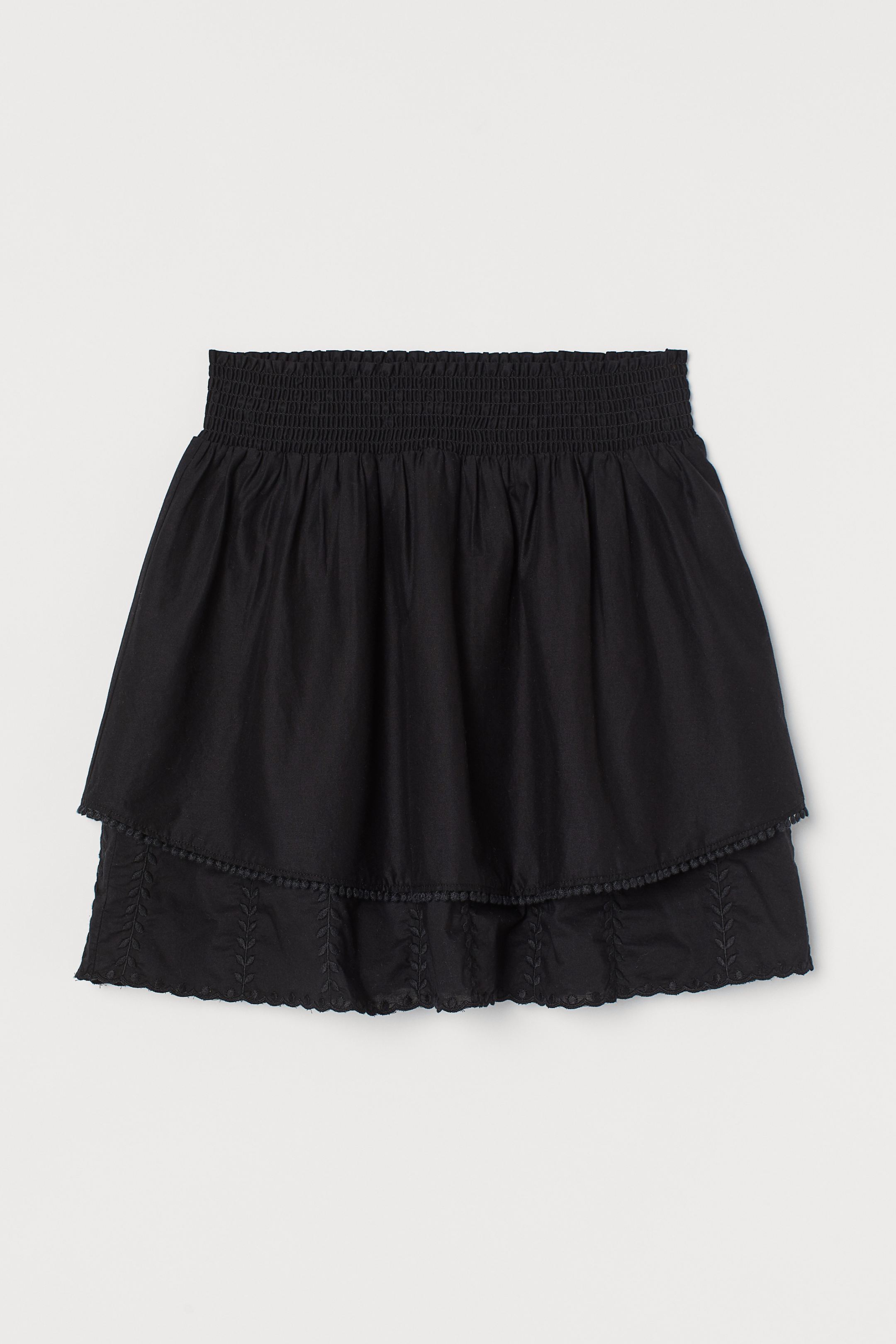Presume de piernas con esta falda negra fluida de algodón con volantes, bordados y cintura elástica. De lo nuevo de H&M por 29,99 euros.