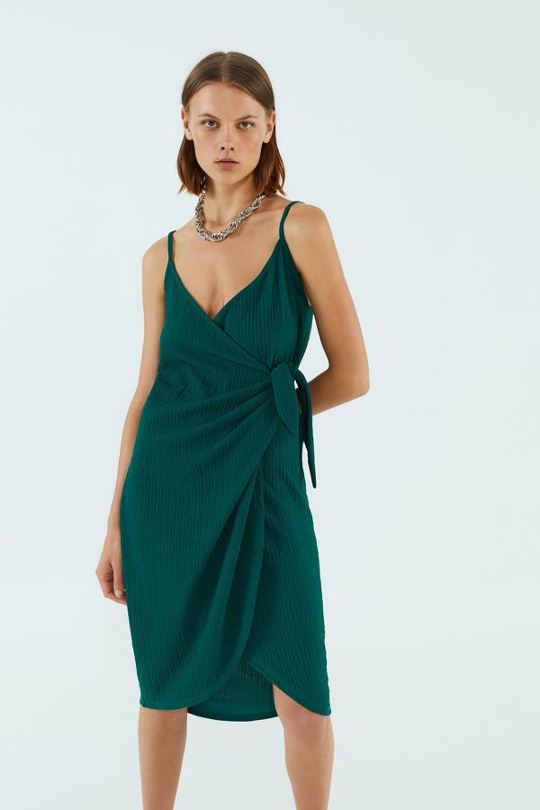 En color verde hoja, vestido cruzado con cierre de nudo, de Sfera (17,99 euros).