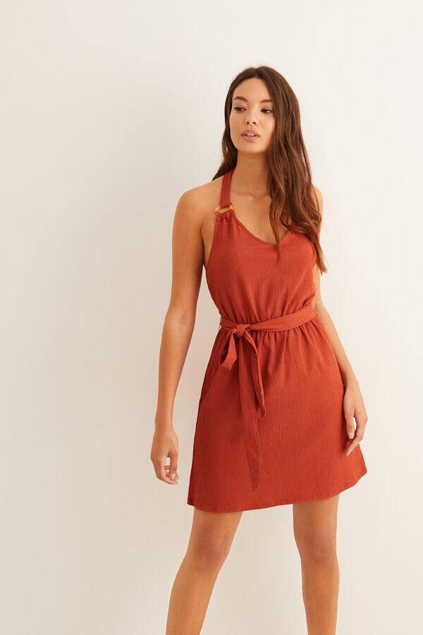 Diseño corto con lazada al cuello para este bonito vestido rojo de Women Secret con nudo en la cintura y arandelas de carey en los tirantes. Está rebajado y de 29,99 euros ha pasado a costar 19,99 euros, entre las tallas XS y L.