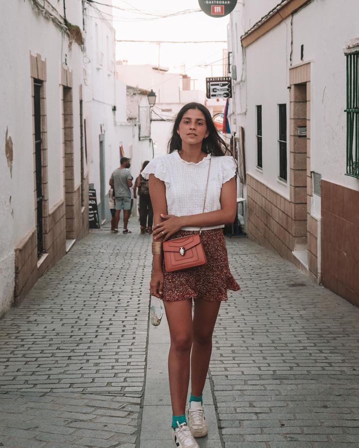 Ir cómoda, fresquita e ideal a la vez es posible con este look de María García de Jaime. Y es que ha combinado una minifalda de estampado floral y corte fluido que seguro que tú también tienes con dos básicos: camiseta de manga corta y sneakers. Ha añadido un bolso bandolera y el detalle de unos calcetines a contraste para dar un toque más sofisticado. ¿Te atreves?