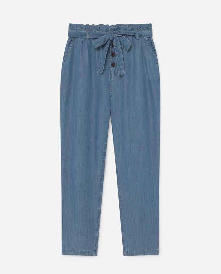 Pantalón fluido de tiro alto con cintura elástica, bolsillos delanteros y traseros, detalle de cinturón con lazada en el mismo tejido y cierre delantero con botones efecto madera (17,99 €), de Lefties.