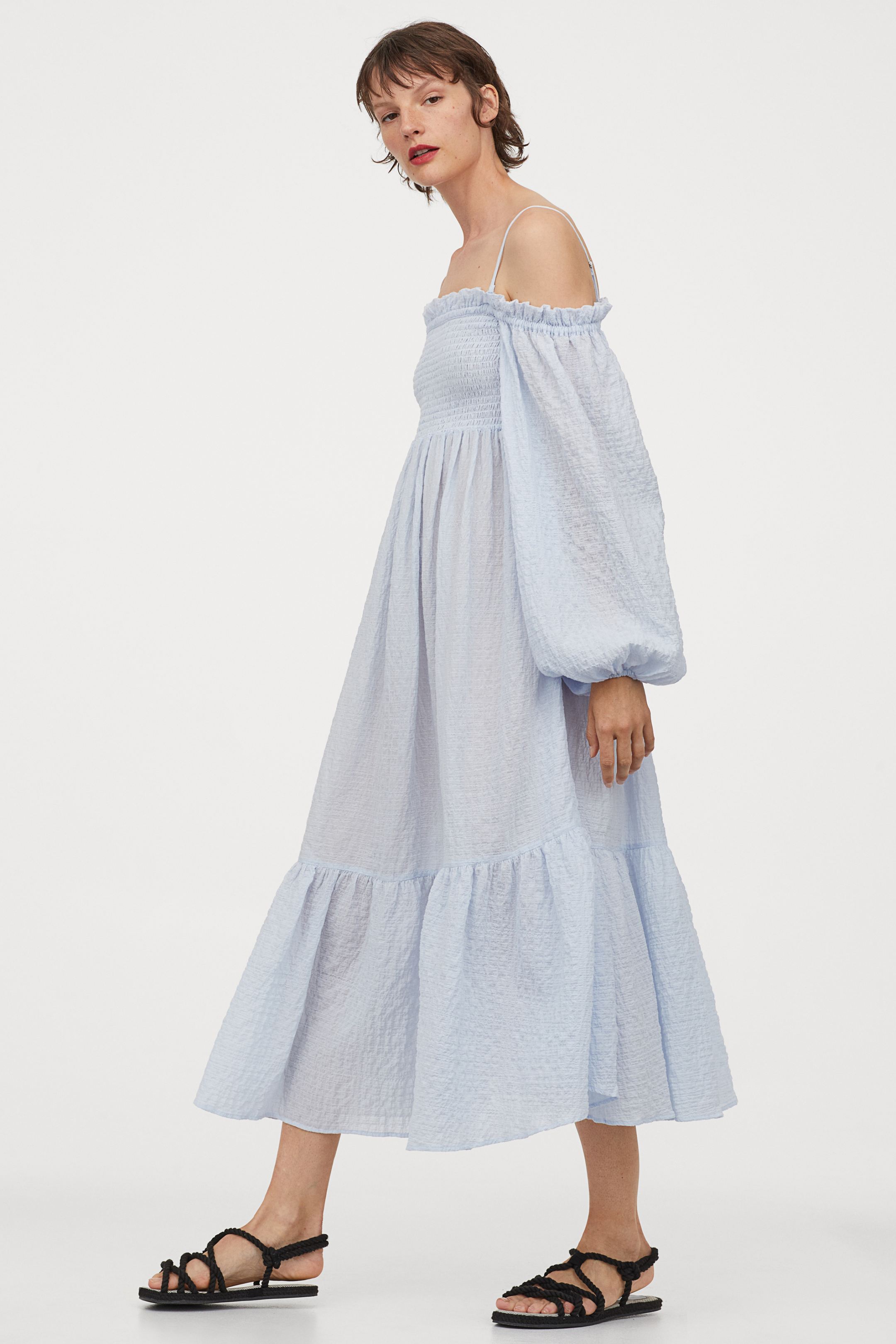 Hombros al descubierto y pecho bonito con este vestido fruncido y largo azul bebé de mangas globo y falda evasé con maxi volumen. De la nueva colección de H&M. (49,99 euros).