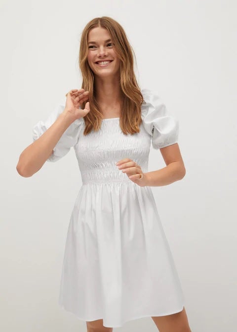 Vestido blanco con panel elástico en el pecho, escote cuadrado, mangas cortas abullonadas y tejido de algodón. (39,99 euros).