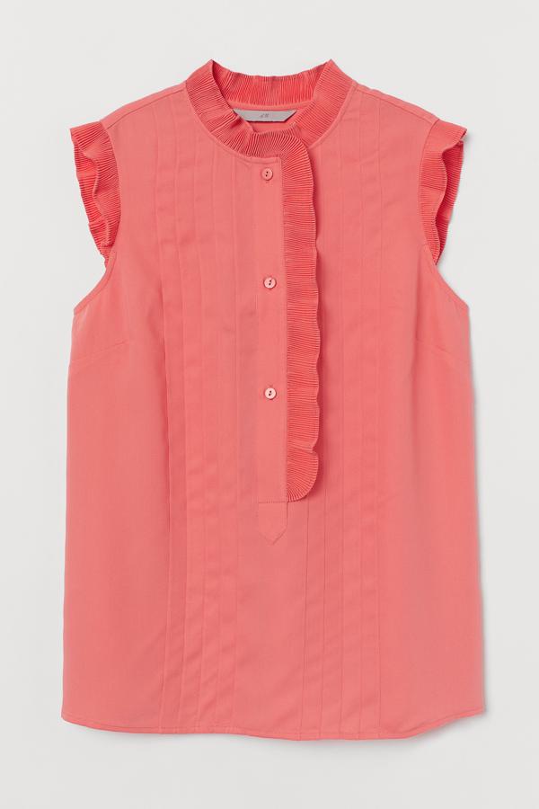 Esta blusa plisada sin mangas en color coral y con pequeños botones delanteros tiene un precio de 24,99 euros.