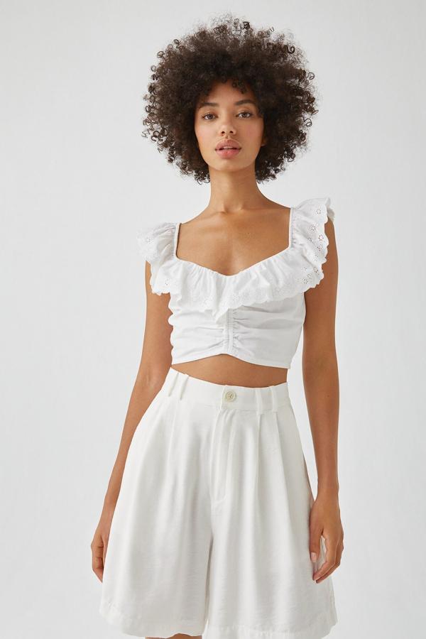 En color blanco, este top cropped con detalle de puntilla en las mangas y un volante es uno de los favoritos de la colección. Con escote en forma de pico y confeccionado en 100% algodón, tiene un precio de 15,99 euros.