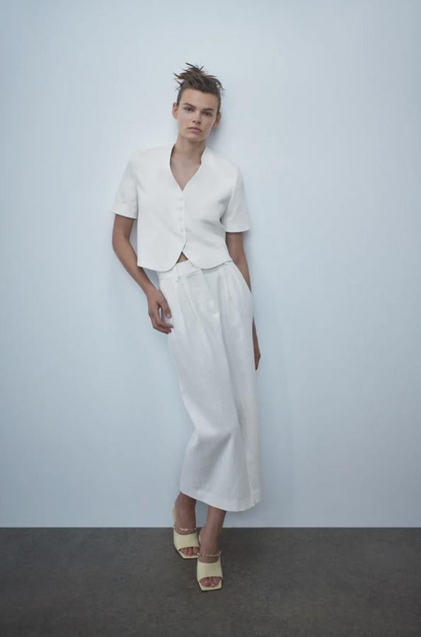 Confeccionada con tejido en mezcla de lino, esta blazer rústica de Zara en color crudo viene con escote de pico y mangas cortas, además de falsos bolsillos de doble vivo en el frontal. Tiene un precio de 29,95 euros y está disponible entre las tallas XS y XL.