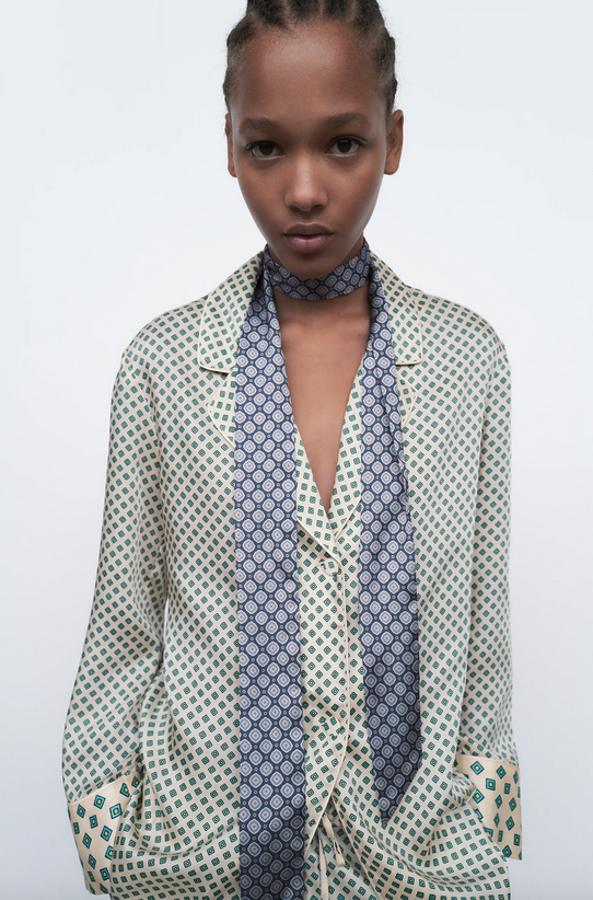 Estampado geométrico en tonos verdes sobre fondo crudo para esta camisa pijamera de diseño ampli con cuello solapa y escote de pico con manga larga. Con detalle de vivo combinado a tono y botones forrados, tiene un precio de 25,95 euros y está disponible entre las tallas XS y XXL.