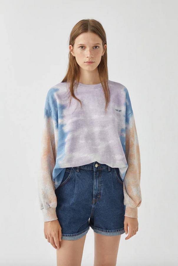 En lila, azul y amarillo, esta propuesta tie-dye de Pull&bear viene con detalle de texto bordado, mangas largas y cuello redondo. Cuesta 19,99 euros y está disponible entre las tallas XS y XL.