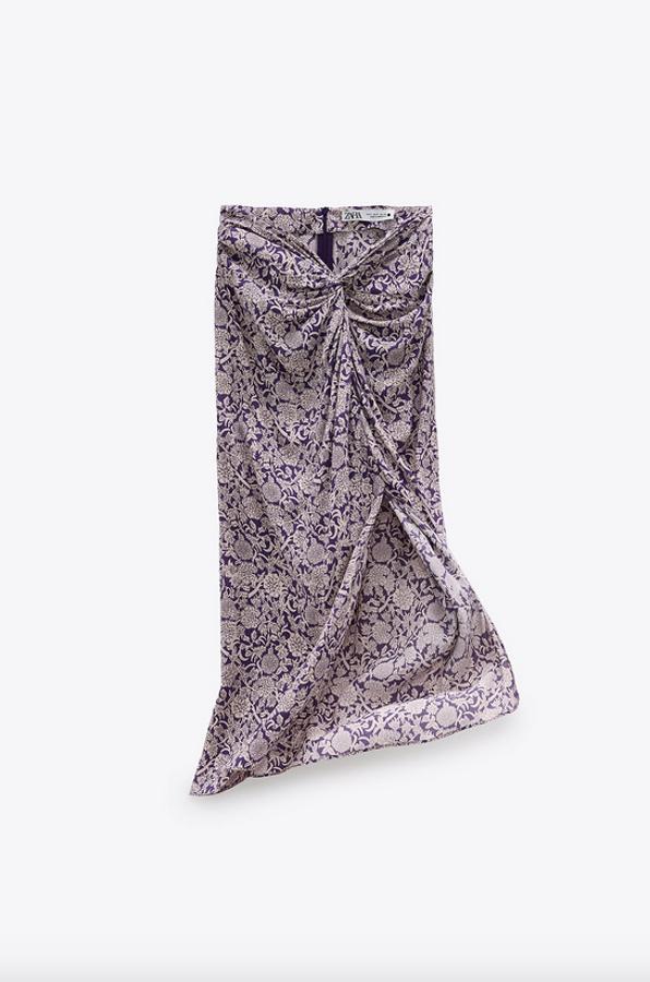 Fondo malva con estampado de flores para esta falda midi de Zara con nudo delantero y bajo con abertura frontal. Tiene un precio de 29,95 euros y está disponible entre las tallas XS y XXL.