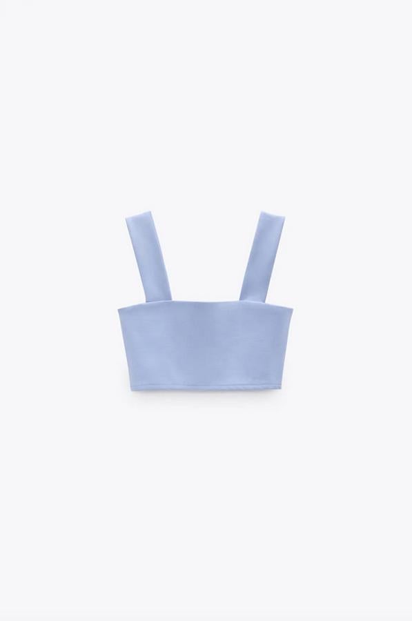 Diseño cropped con escote recto y tirantes anchos para este top de Zara que cuesta 7,95 euros y está disponible en las tallas S, M y L.