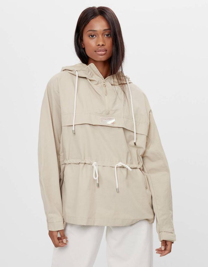 Confeccionada en nylon y con capucha, esta cazadora de Bershka en color crudo viene con bolsillos en la pechera y cintura ajustada con cordón. Con las mangas largas acabadas en puño elástico, tiene un precio de 29,99 euros y está disponible entre las tallas XS y M.