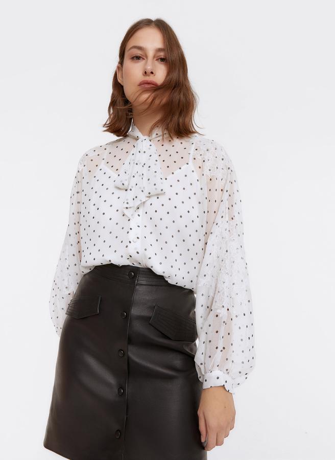 Camisa de bambula con estampado de microlunares, blondas en las mangas y en el bajo y lazada al cuello, de Uterqüe (89 €).