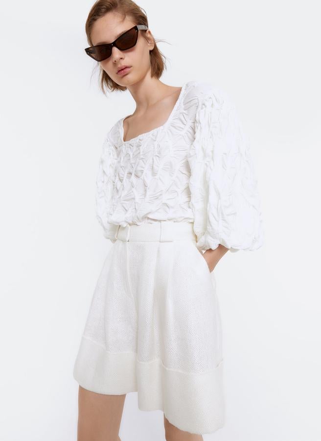 Blusón en tejido de efecto arrugado, con mangas abullonadas y escote cuadrado, de Uterqüe (59 €).