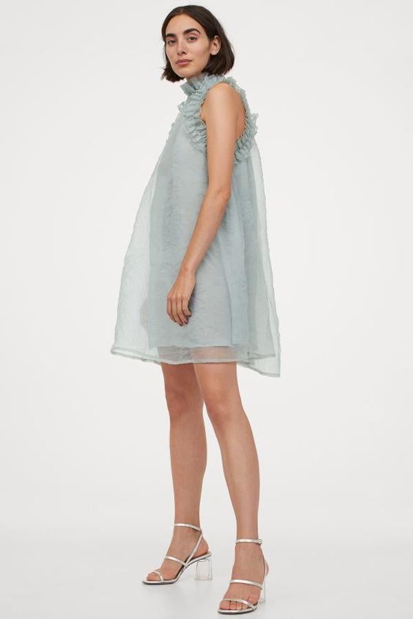 En verde menta, con volantes en el cuello y las mangas sisa, este vestido corto en crepé de organza es de H&M. Tiene falda con maxivuelo y un precio de 49,99 euros y podemos encontrarlo entre las tallas XS y XL.