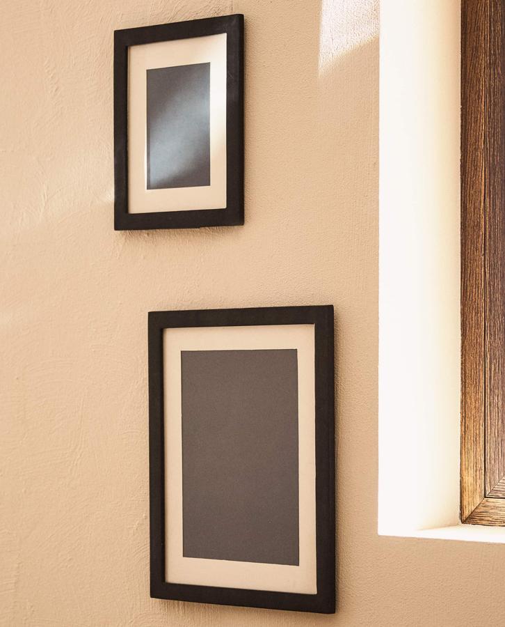 Este marco de fotos de madera negra con detalle de doble paspartú incluye ganchos para colgar y está disponible en dos medidas. Desde 17,99 euros.