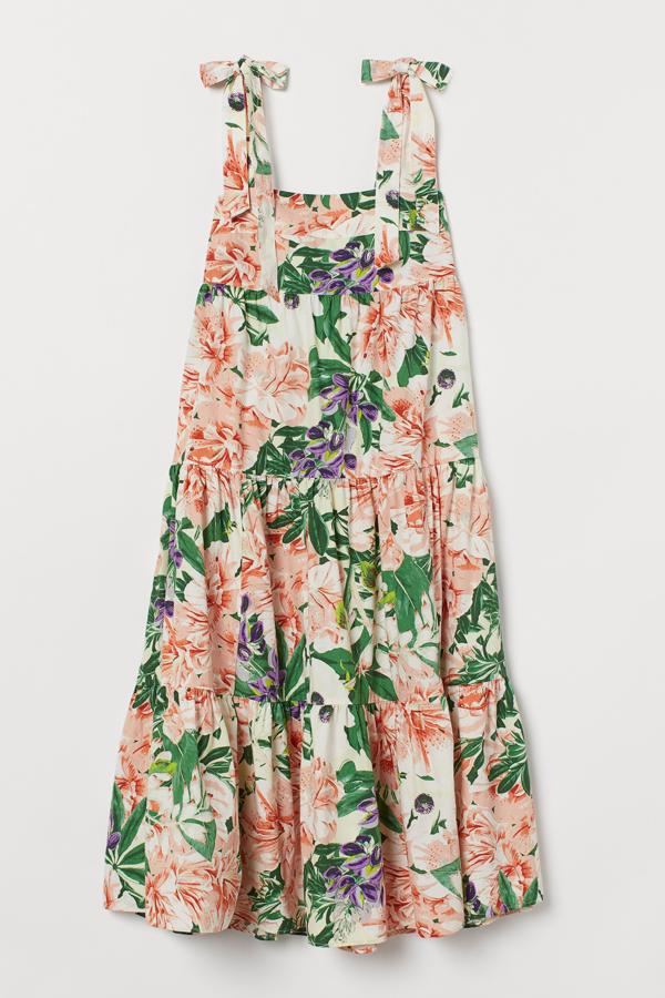Con fondo blanco y estampado floral, este vestido de algodón con tirantes anchos anudados en el hombro y espalda fruncida es de H&M y tiene un precio de 29,99 euros.
