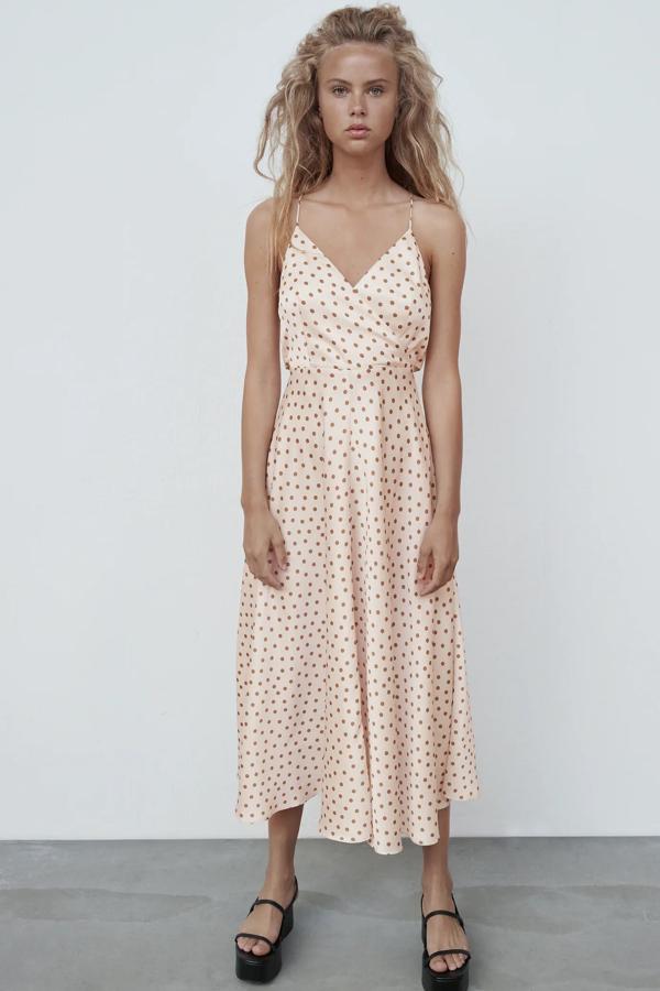 En color crudo con lunares marrones, este vestido satinado con escote de pico y tirantes cruzados en la espalda es de Zara y tiene un precio de 39,95 euros.