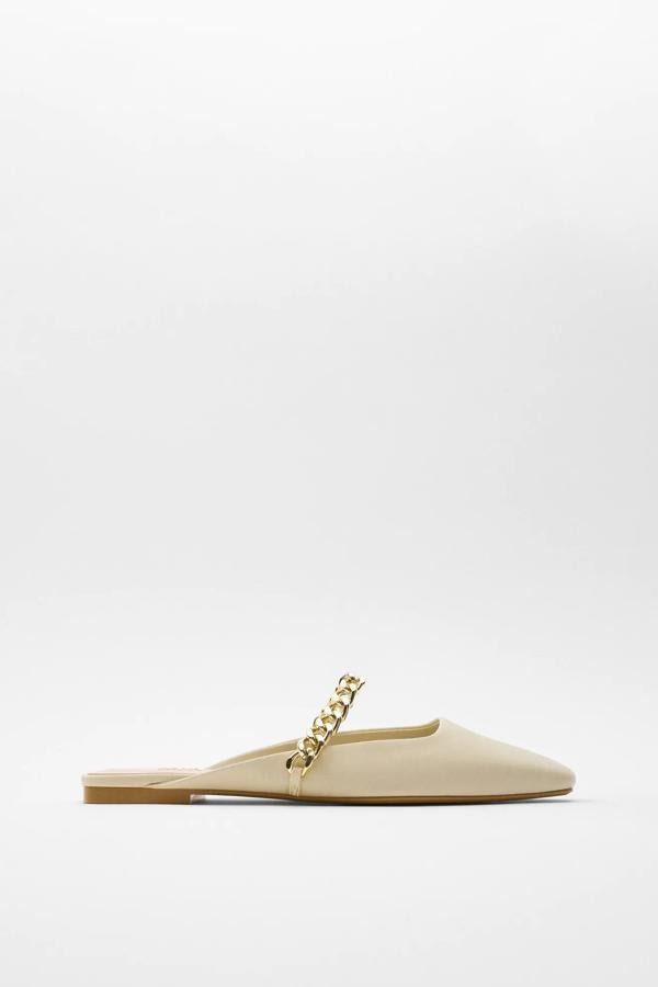 En color crudo, este zapato plano destalonado con detalle de cadena dorada es de Zara y tiene un precio de 25,95 euros.