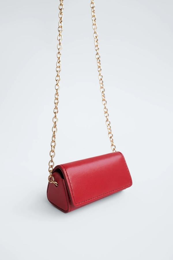 Zara nos propone este mini bolso con forma triangular que cuenta con cierre de imán. Con asa metálica de hombro y detalle de espejo en el interior, tiene un precio de 9,95 euros.