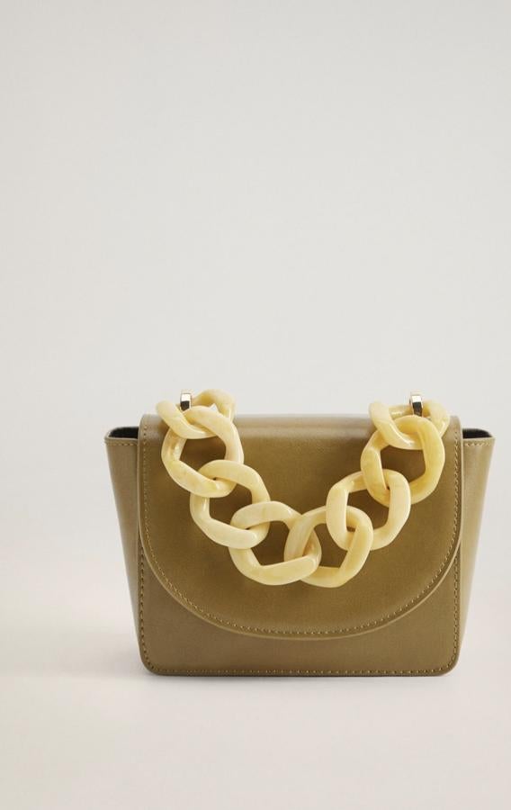 En color verde oliva (también está disponible en negro), este minibolso con solapa frontal cuenta con asa de cadena de eslabones grandes y asa larga ajustable. Es de Mango y tiene un precio de 19,99 euros.
