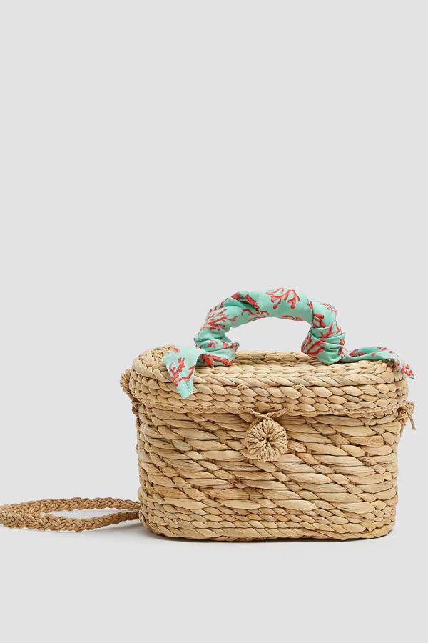 De tamaño pequeño, esta cesta bandolera tipo caja con cierre mediante botón cuenta con detalle de pañuelo en el asa y tiene un precio de 12,99 euros. Es de Pull & Bear.
