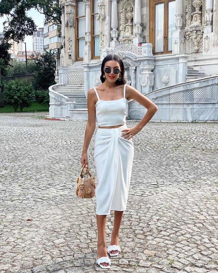 Esta influencer optó por llevarla en un look monocolor y apostando por el blanco, el color perfecto para resaltar el moreno en verano. Añadió así un top de tirantes y unas sandalias tipo mule con tira trenzada.