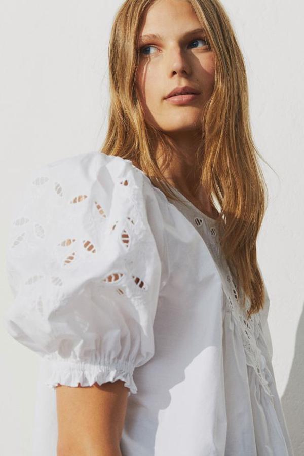 Confeccionada en popelina de algodón con inserciones caladas, este modelo con media manga globo que tiene remate de elástico fino y está ligeramente abullonada en el hombro viene con abertura en la espalda. Tiene un precio de 24,99 euros y podemos encontrarla entre las tallas M y XXL.