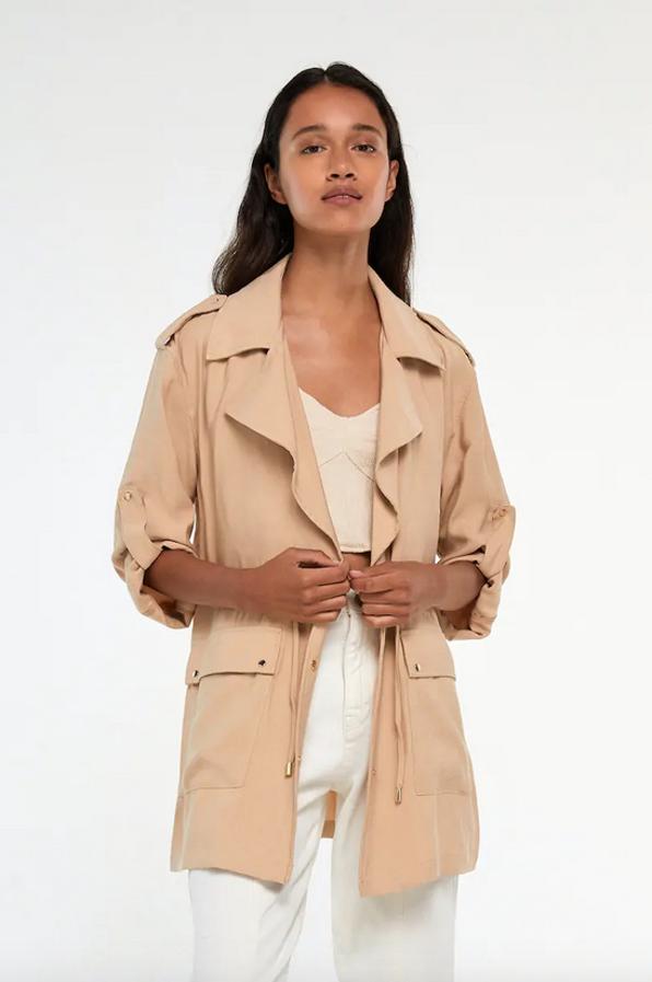Disponibles en color ocre y en arena, esta cazadora estilo sahariana con detalle de cordón ajustable en la cintura tiene las mangas largas con vuelta, cuello de solapa y bolsillos laterales de tapeta. De 29,99 euros ha pasado a 19,99 euros y podemos encontrar ambos tonos entre las tallas XS y XL.