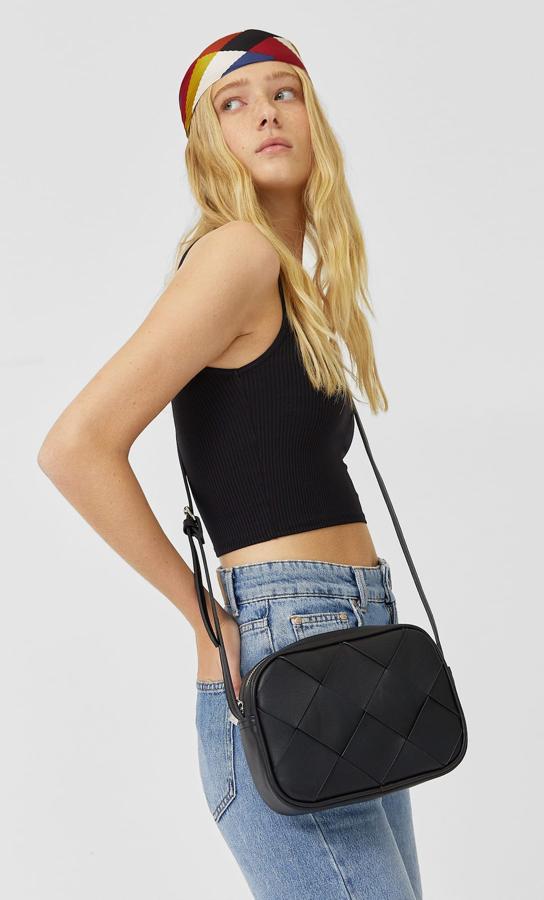 En Stradivarius hemos encontrado esta bonita bandolera trenzada en color negro con asa de hombro fina y cremallera superior metalizada. Cuesta 12,99 euros.