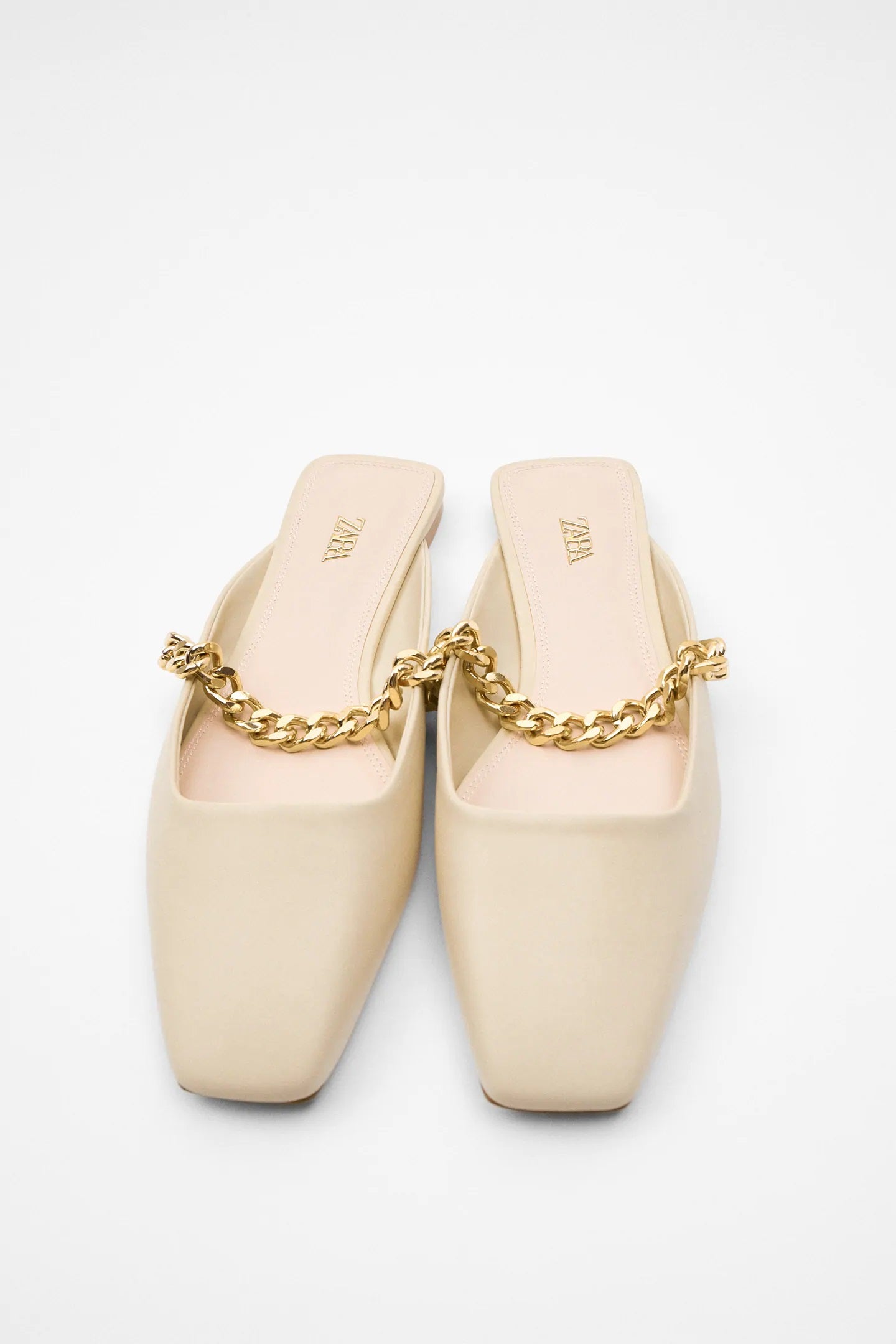 Mules en color crema con detalle de cadenas para dar el toque de originalidad a cualquier look de entretiempo. (25,95 euros).